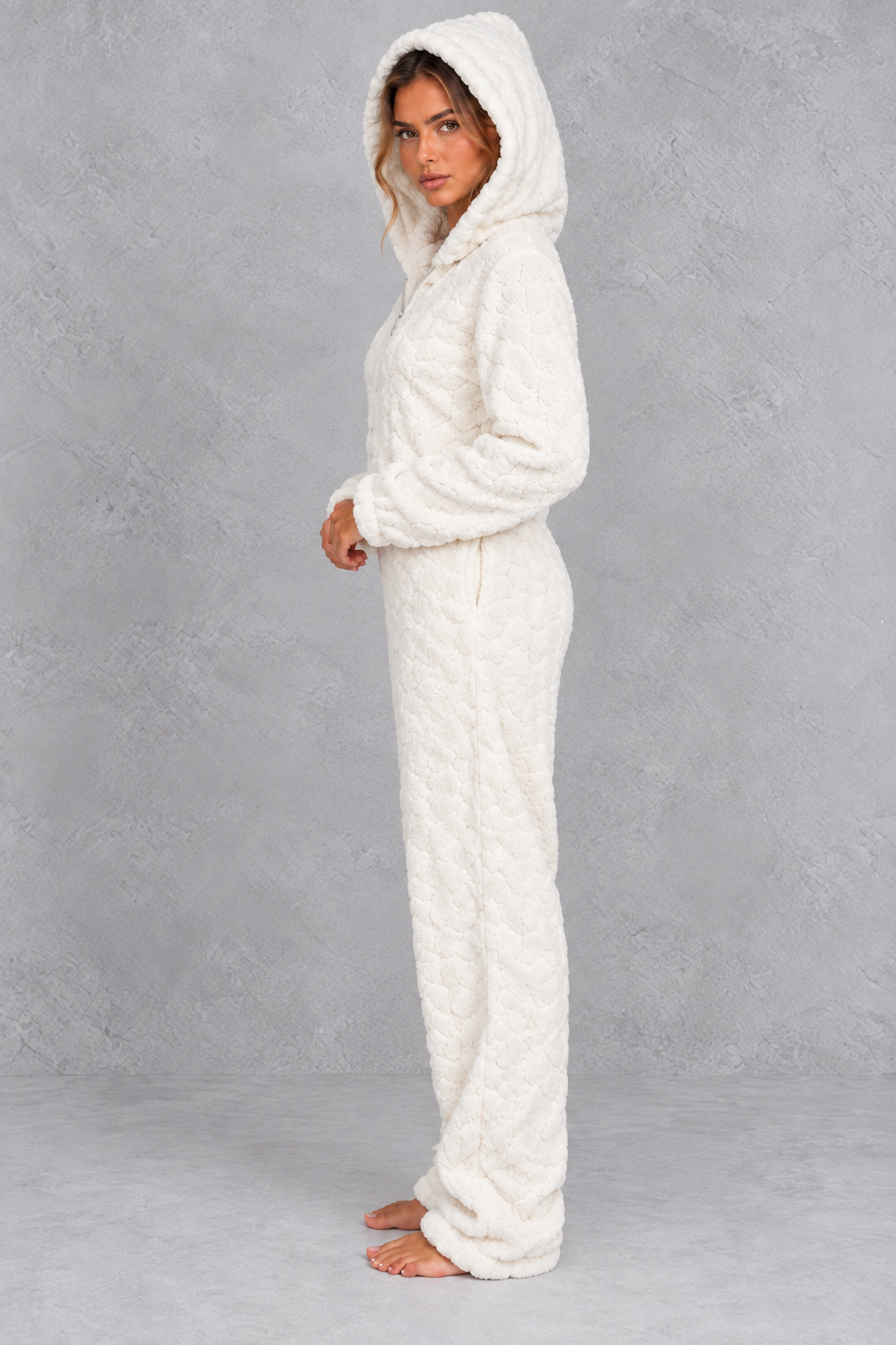Women’s teddy fleece jumpsuit with a plush fluffy texture, large hood, full-length zip, long sleeves and relaxed one-piece silhouette.