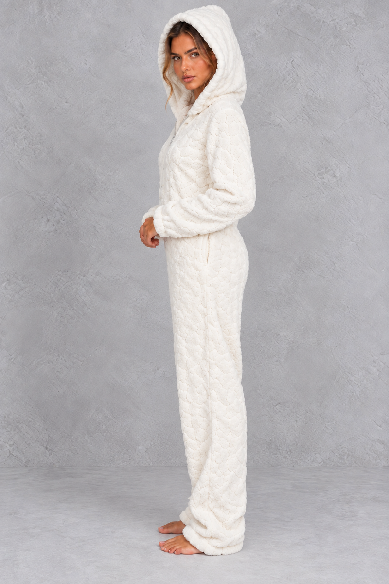 Women’s teddy fleece jumpsuit with a plush fluffy texture, large hood, full-length zip, long sleeves and relaxed one-piece silhouette.