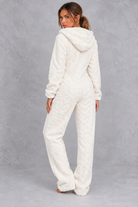 Women’s teddy fleece jumpsuit with a plush fluffy texture, large hood, full-length zip, long sleeves and relaxed one-piece silhouette.