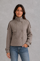Women’s houndstooth button jacket with high neck and structured woven design.