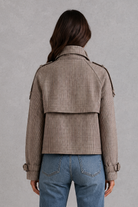 Women’s houndstooth button jacket with high neck and structured woven design.