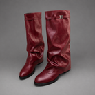 Women’s knee-high slouch boots with pointed toe, low block heel and metal cuff detail.