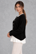 Women’s layered knit cardigan with a crew neckline, gold-tone button front, long sleeves and contrasting white pleated shirt-style hem.