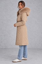 Women’s long hooded winter parka with faux fur trim, a plush-lined interior, adjustable drawstring waist and relaxed silhouette.