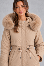 Women’s long hooded winter parka with faux fur trim, a plush-lined interior, adjustable drawstring waist and relaxed silhouette.