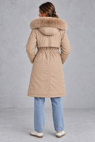 Women’s long hooded winter parka with faux fur trim, a plush-lined interior, adjustable drawstring waist and relaxed silhouette.