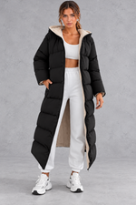Women's long hooded puffer coat in Black – front view, worn open