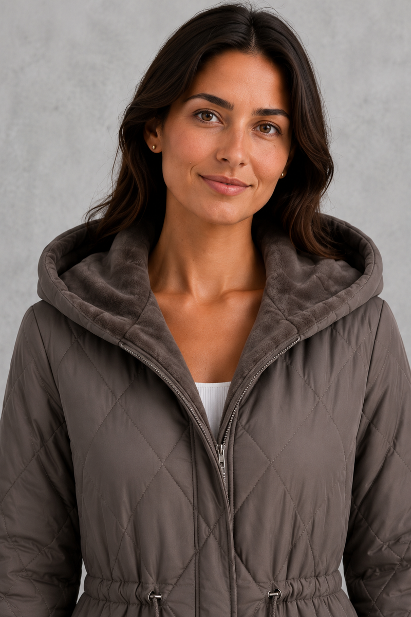 Women’s long quilted puffer coat with classic diamond quilting, a soft faux fur collar, adjustable drawstring waist and practical front pockets.