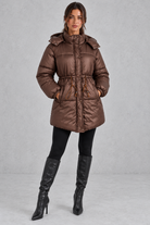 Women’s longline hooded puffer coat with quilted padding, a high neckline, adjustable drawstring waist and practical side pockets.