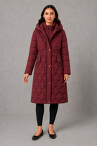Women’s longline hooded puffer coat with insulated padding, waterproof and windproof protection, practical pockets and extended winter coverage.