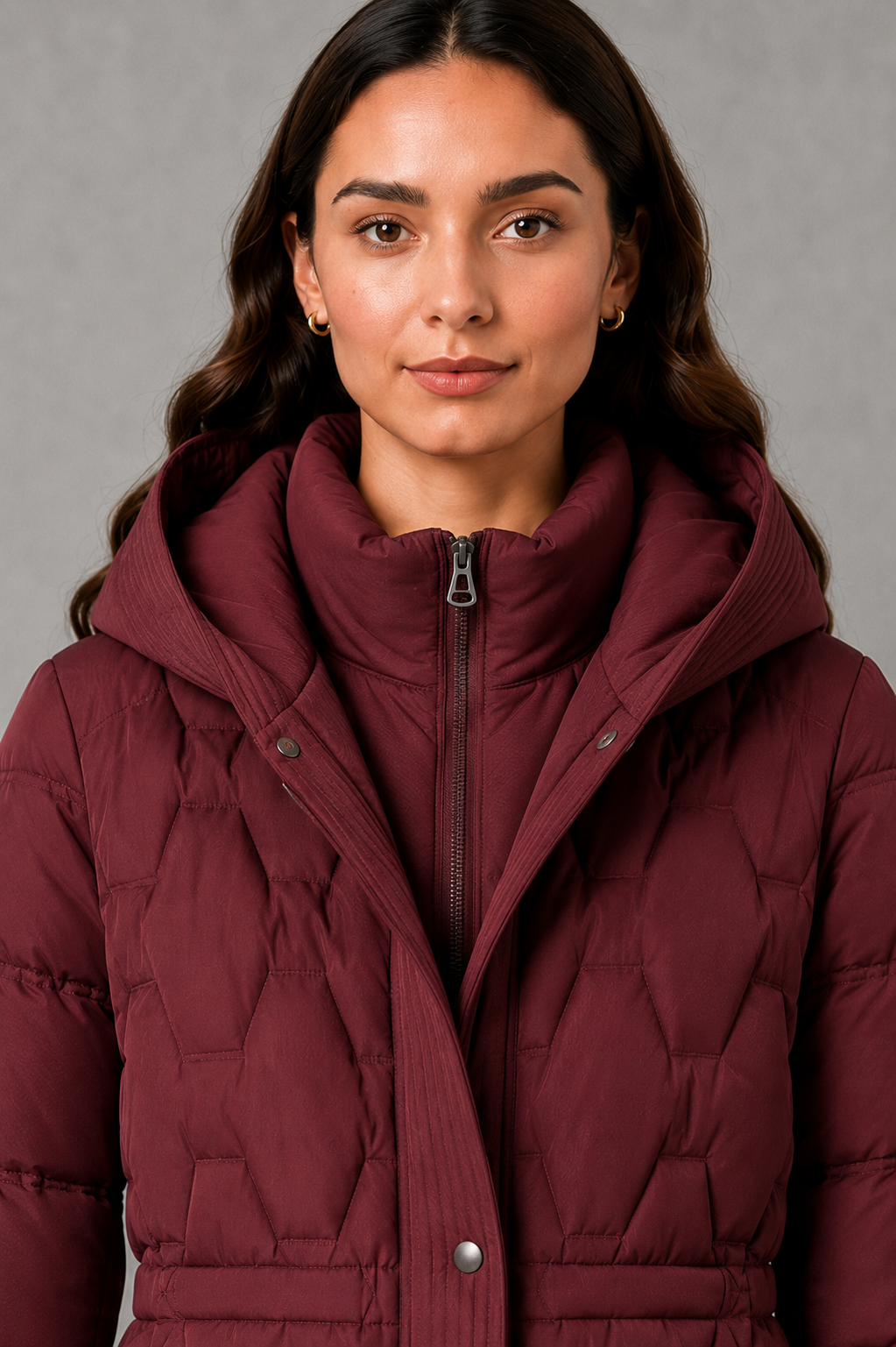 Women’s longline hooded puffer coat with insulated padding, waterproof and windproof protection, practical pockets and extended winter coverage.
