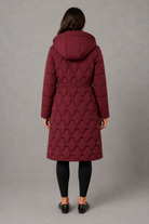 Women’s longline hooded puffer coat with insulated padding, waterproof and windproof protection, practical pockets and extended winter coverage.