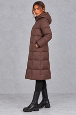Women’s longline hooded puffer winter coat with streamlined quilting, a high neckline, full zip front and practical side pockets.