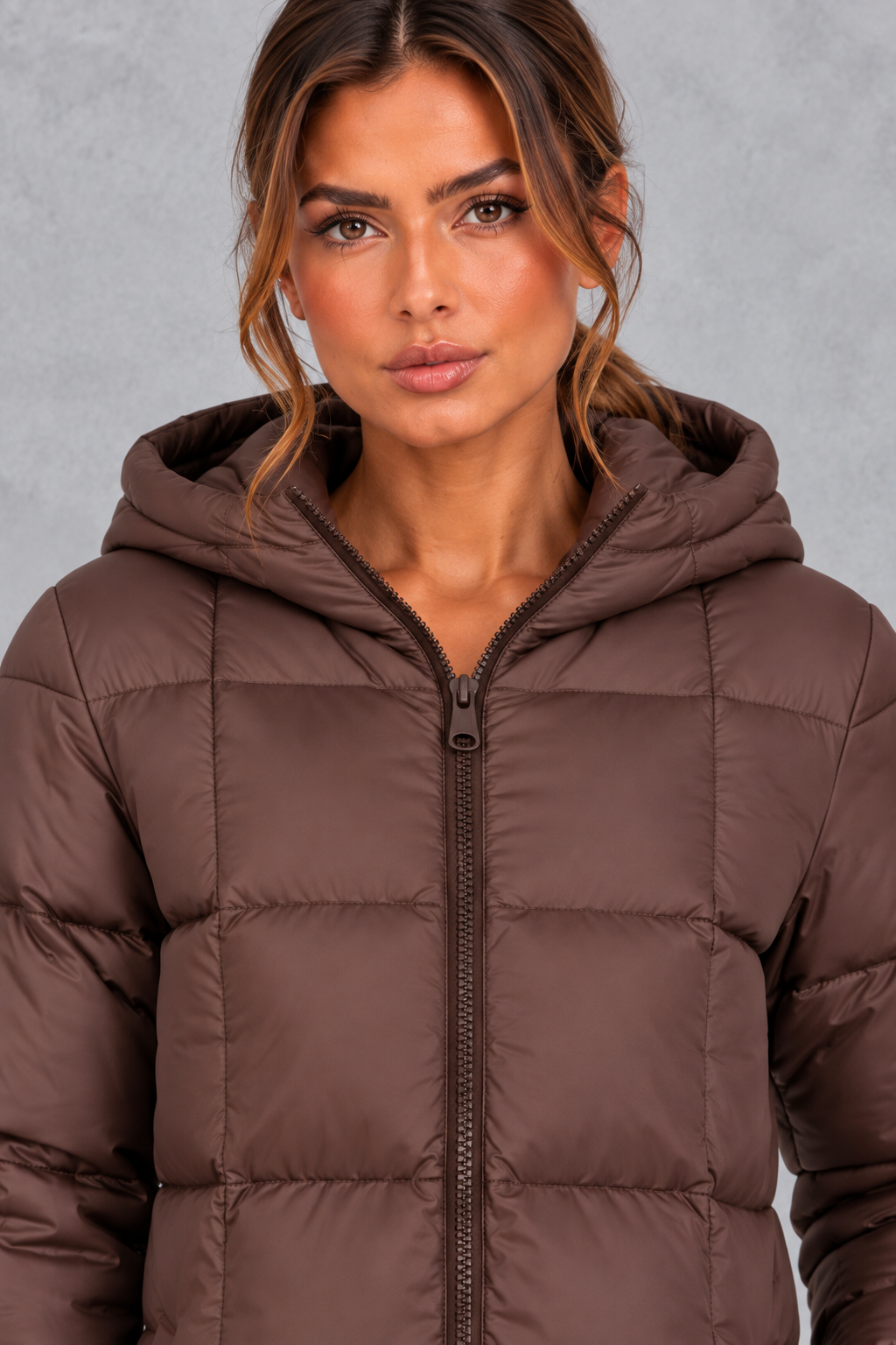 Women’s longline hooded puffer winter coat with streamlined quilting, a high neckline, full zip front and practical side pockets.