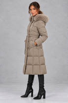 Women’s longline quilted puffer coat with a detachable faux fur hood, adjustable drawstring waist and warm padded construction.