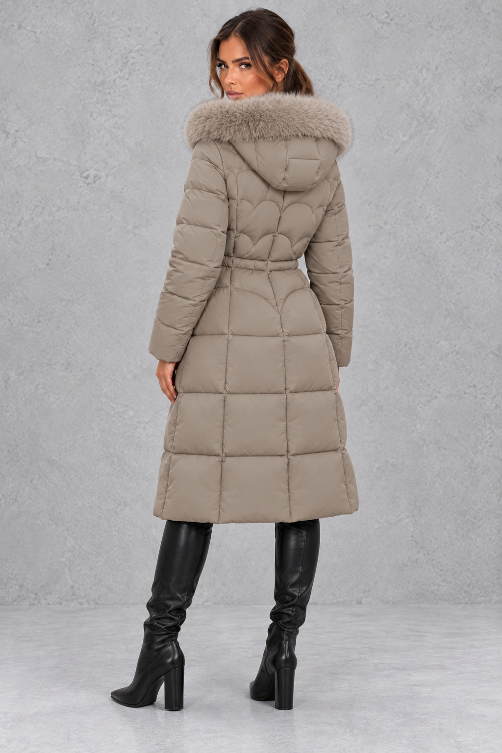 Women’s longline quilted puffer coat with a detachable faux fur hood, adjustable drawstring waist and warm padded construction.