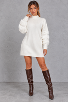 Women's white knit jumper mini dress with fluffy banded long sleeves and high neck – front view