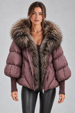 Women’s oversized puffer jacket with a plush faux fur-trimmed hood, voluminous padding, dropped shoulders and extended ribbed cuffs.