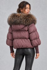 Women’s oversized puffer jacket with a plush faux fur-trimmed hood, voluminous padding, dropped shoulders and extended ribbed cuffs.