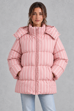 Women’s pink and white striped oversized hooded puffer jacket with horizontal quilting, a high stand collar and voluminous padded silhouette.