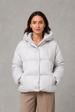 Women’s oversized hooded puffer jacket with a protective high collar, wide padded sleeves and a relaxed hip-length silhouette for winter layering.