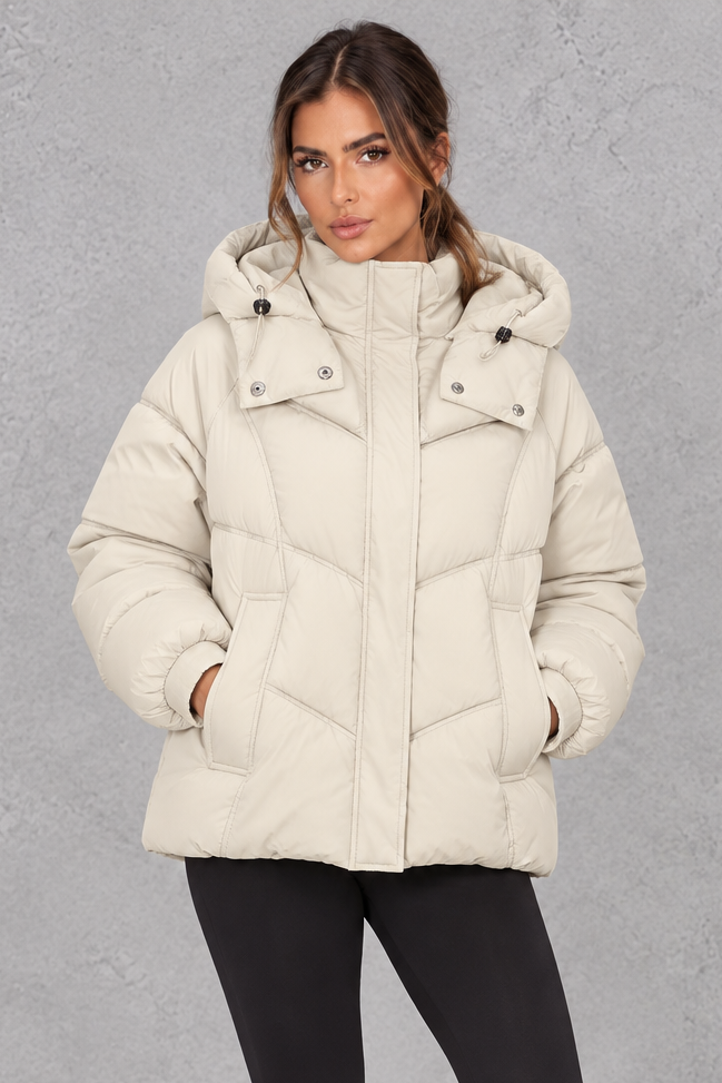Women’s cream oversized hooded puffer jacket with geometric quilting, generous padding, a high collar and adjustable drawcord hem.