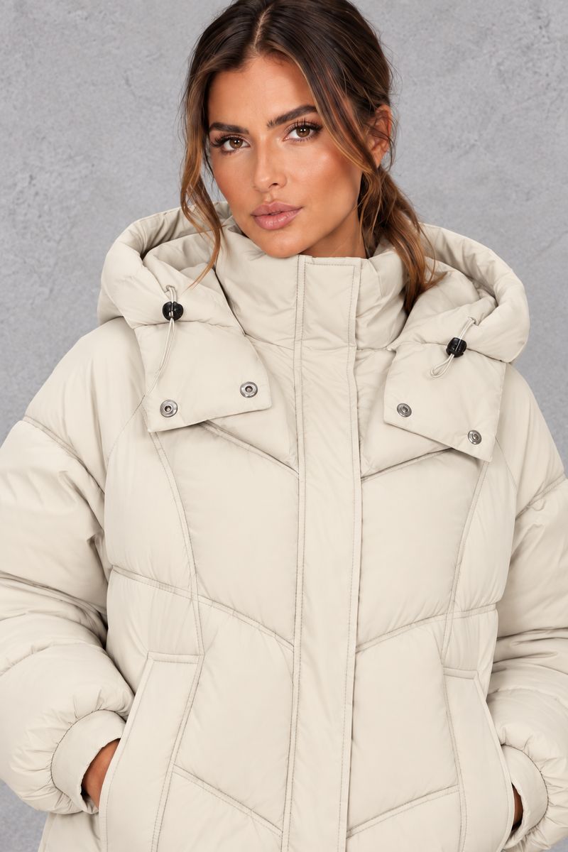 Women’s cream oversized hooded puffer jacket with geometric quilting, generous padding, a high collar and adjustable drawcord hem.