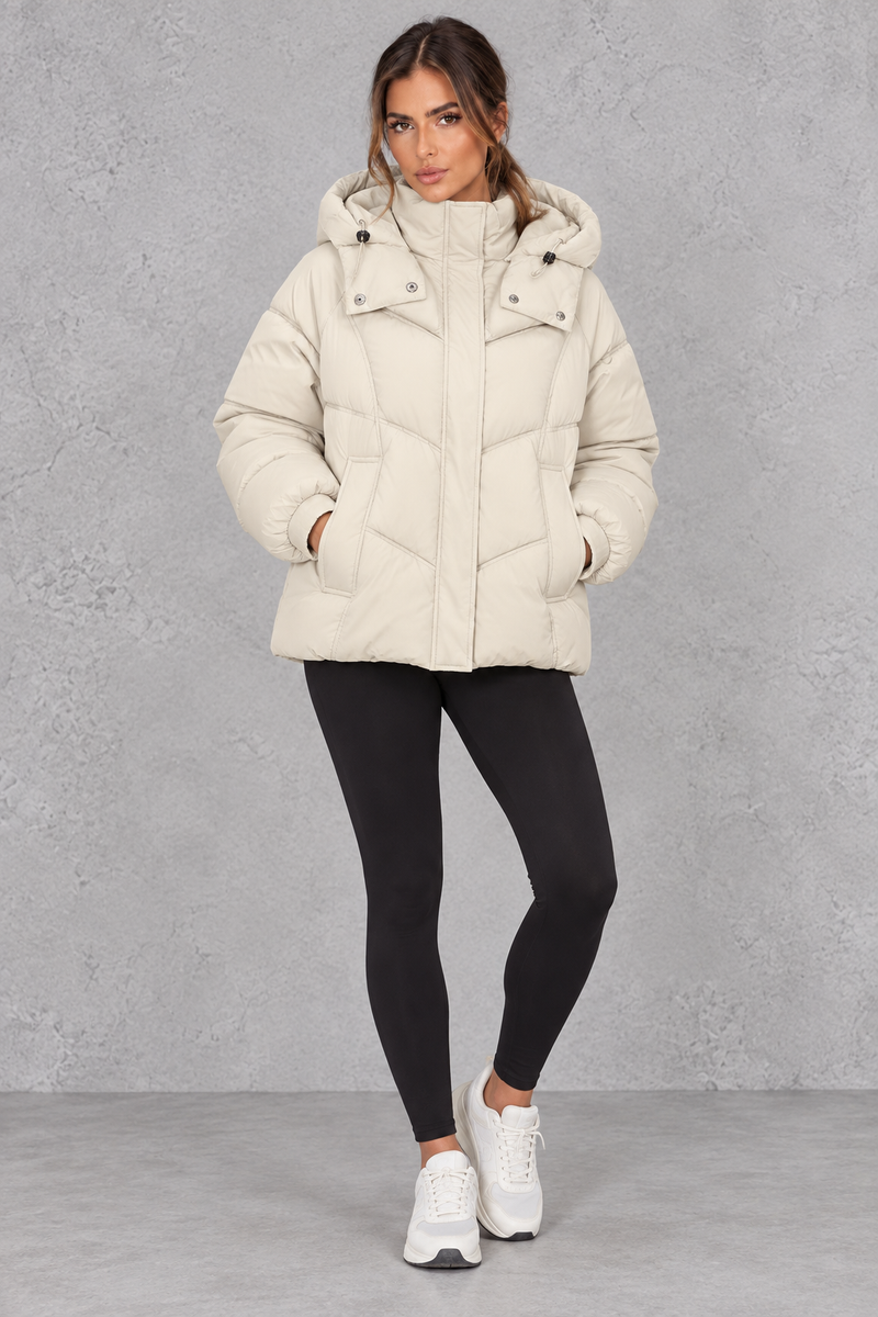 Women’s cream oversized hooded puffer jacket with geometric quilting, generous padding, a high collar and adjustable drawcord hem.