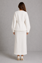 Women’s two piece tailored suit with a fitted V-neck peplum jacket, voluminous long sleeves and coordinating maxi pencil skirt for an elegant silhouette.