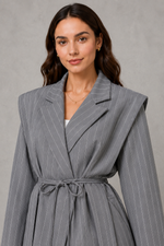 Women’s pinstripe longline blazer with structured shoulders, lapel collar and adjustable tie waist belt.