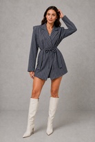 Women’s pinstripe longline blazer with structured shoulders, lapel collar and adjustable tie waist belt.