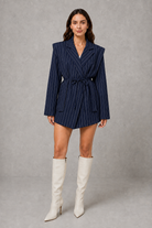 Women’s pinstripe longline blazer with structured shoulders, lapel collar and adjustable tie waist belt.