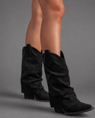 Women’s pointed toe knee high boots with a low chunky heel and relaxed Western-inspired shaft in a neutral shade.