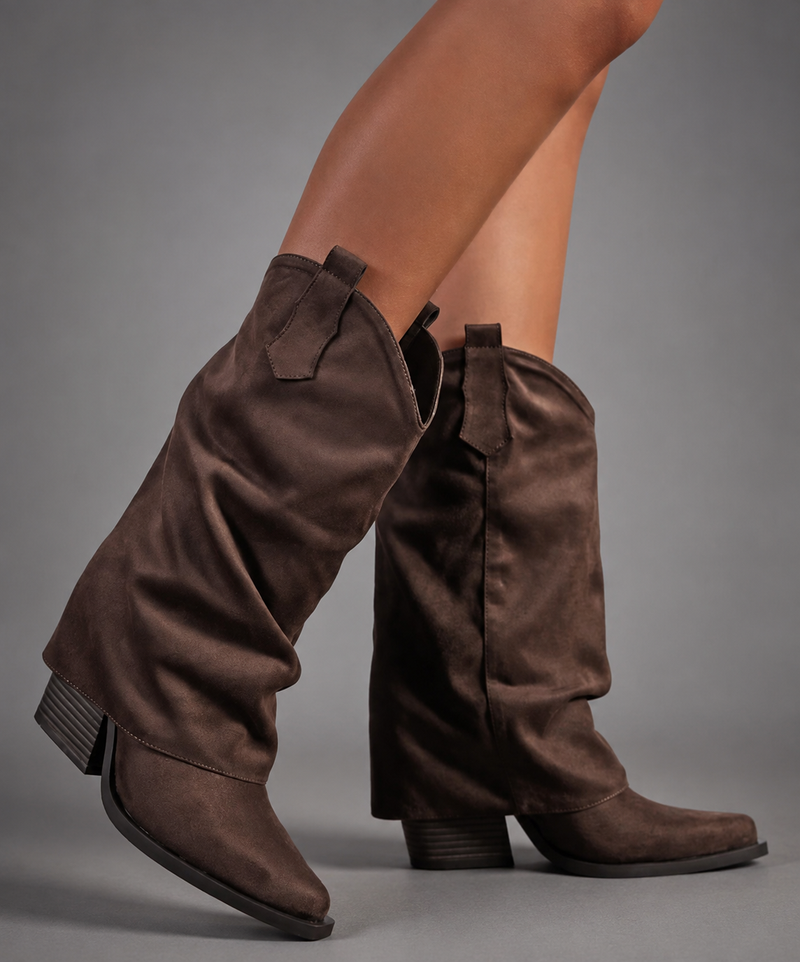 Women’s pointed toe knee high boots with a low chunky heel and relaxed Western-inspired shaft in a neutral shade.