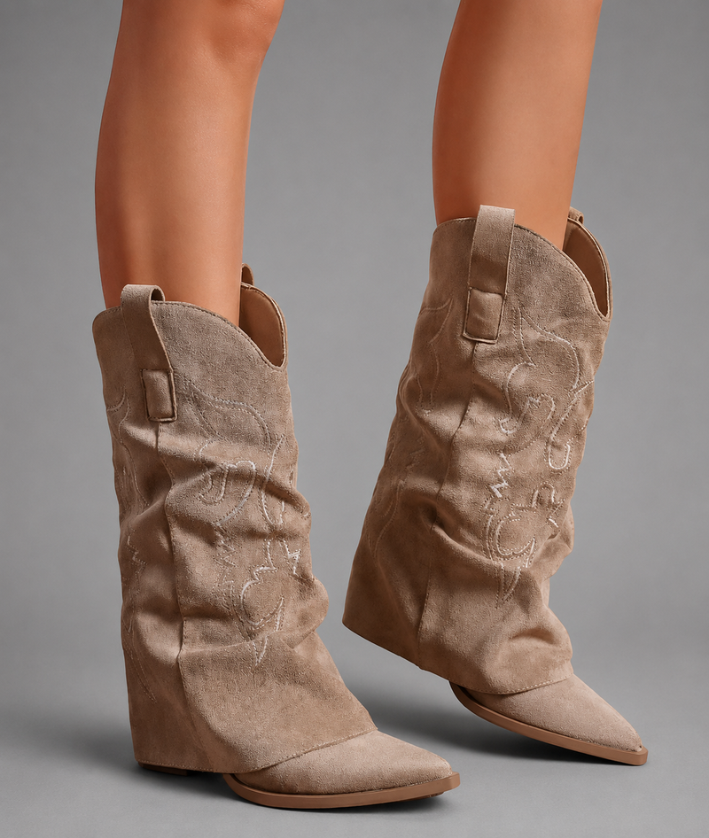 Women’s pointed toe knee high boots with a low chunky heel and relaxed Western-inspired shaft in a neutral shade.