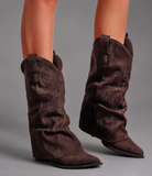 Women’s pointed toe knee high boots with a low chunky heel and relaxed Western-inspired shaft in a neutral shade.