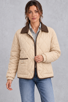Women's beige diamond quilted jacket with brown cord collar and trim – front view