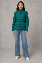 Women’s quilted puffer jacket with horizontal padding, high stand collar, zip-front fastening and a lightweight streamlined silhouette.