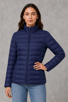Women’s quilted puffer jacket with horizontal padding, high stand collar, zip-front fastening and a lightweight streamlined silhouette.