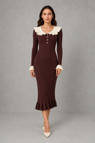Women’s ribbed knit midi dress with a statement ruffle collar, decorative front buttons, fitted silhouette, long sleeves and flared ruffle cuffs.
