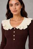 Women’s ribbed knit midi dress with a statement ruffle collar, decorative front buttons, fitted silhouette, long sleeves and flared ruffle cuffs.