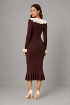 Women’s ribbed knit midi dress with a statement ruffle collar, decorative front buttons, fitted silhouette, long sleeves and flared ruffle cuffs.