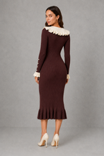 Women’s ribbed knit midi dress with a statement ruffle collar, decorative front buttons, fitted silhouette, long sleeves and flared ruffle cuffs.