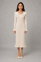 Women’s ribbed knit midi dress with a statement ruffle collar, decorative front buttons, fitted silhouette, long sleeves and flared ruffle cuffs.