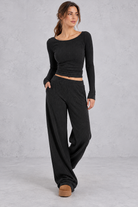 Women's black ribbed knit co-ord set with crop top and wide leg trousers with pockets – front view
