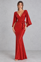 Women’s sequin V-neck evening dress with long raglan sleeves, a high-waisted silhouette, sparkling embellishments and an elegant split detail.