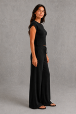 Women’s sleeveless knitted two piece co-ord with button-front fitted top and matching relaxed wide leg drawstring trousers.