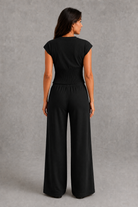 Women’s sleeveless knitted two piece co-ord with button-front fitted top and matching relaxed wide leg drawstring trousers.