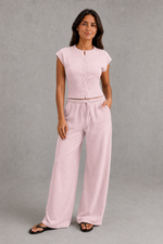 Women’s sleeveless knitted two piece co-ord with button-front fitted top and matching relaxed wide leg drawstring trousers.