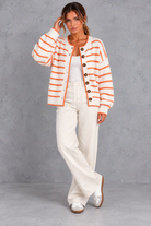 Women's white striped button up knit cardigan – full-length front view with wide-leg trousers